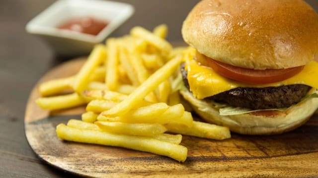 A cheeseburger and fries on a wooden board